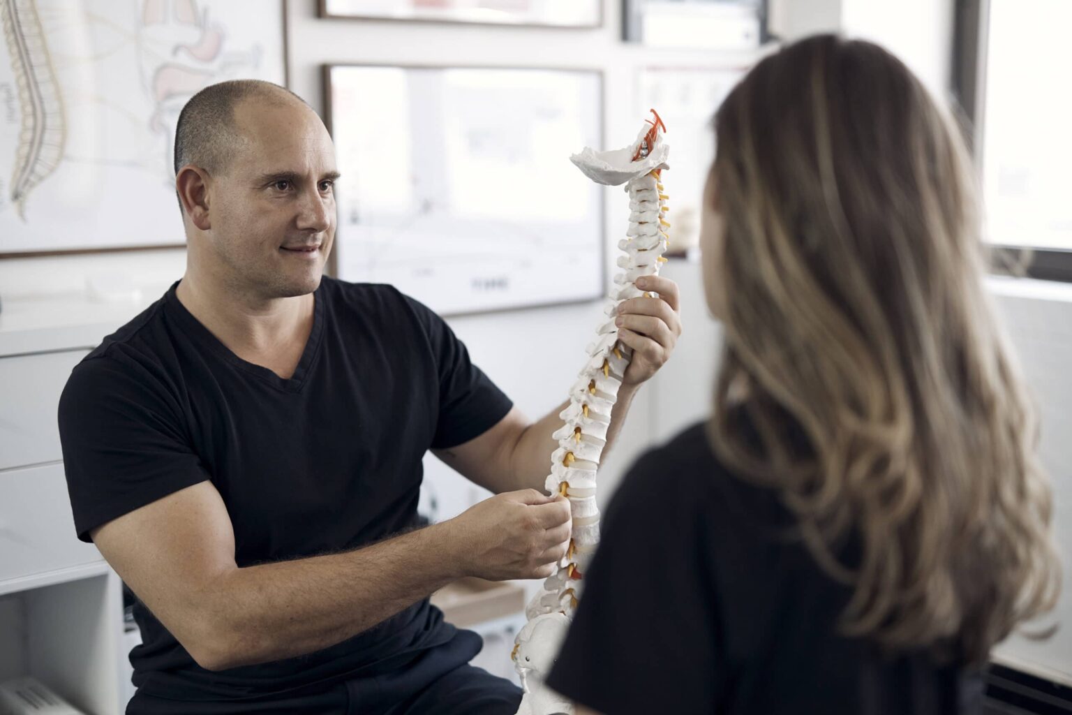 Chiropractor performing posture and spinal assessment.